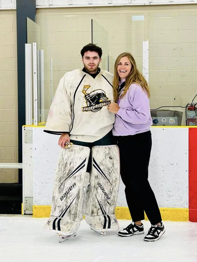 A goalie in full gear standing with the founder