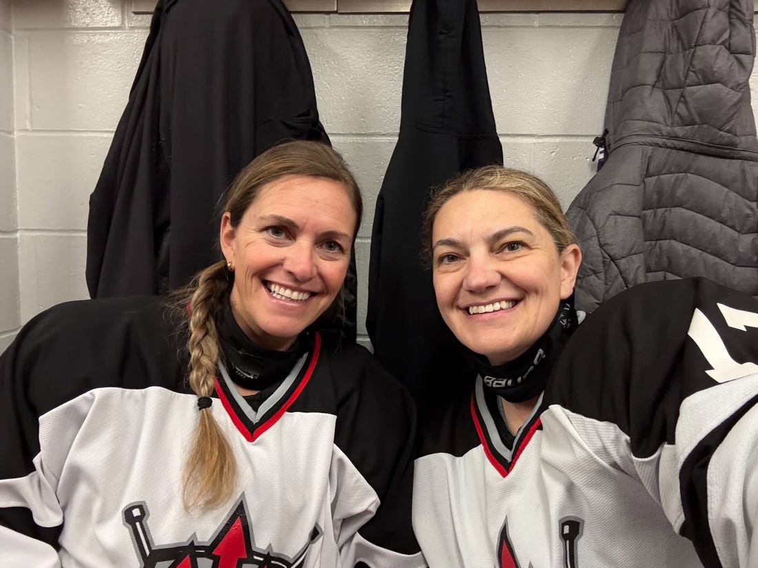 Two players in the dressing room smiling before a game