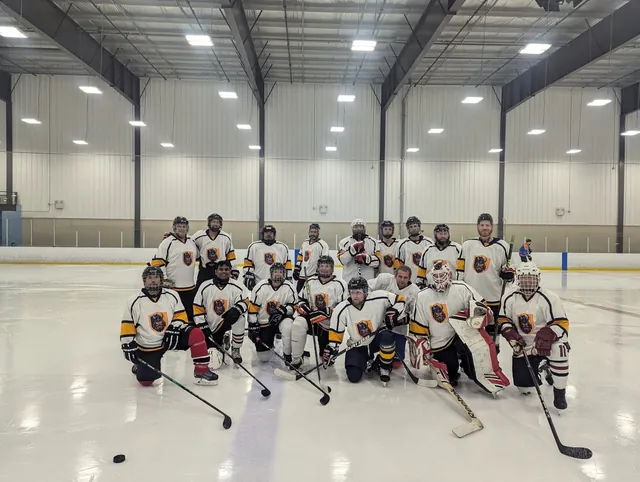 A wide photo of many players gathered across the ice surface