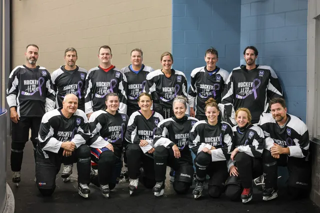 Volunteers and players in Hockey for Hope jerseys gathered for a group photo