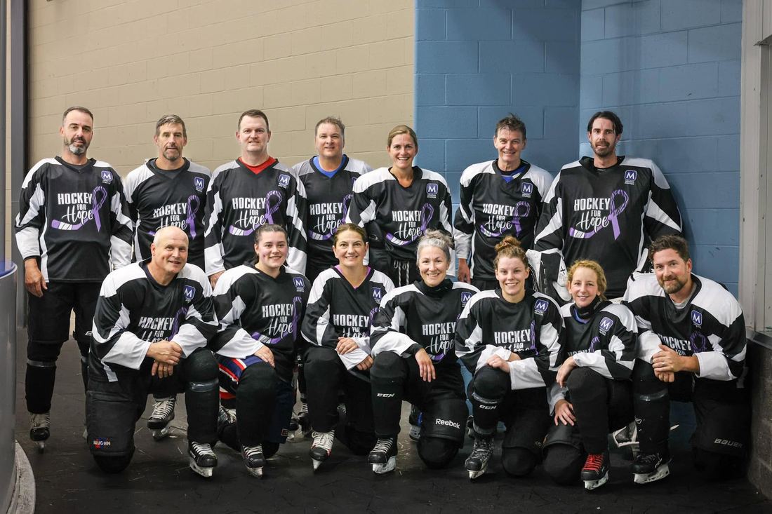 Volunteers and players in Hockey for Hope jerseys gathered for a group photo